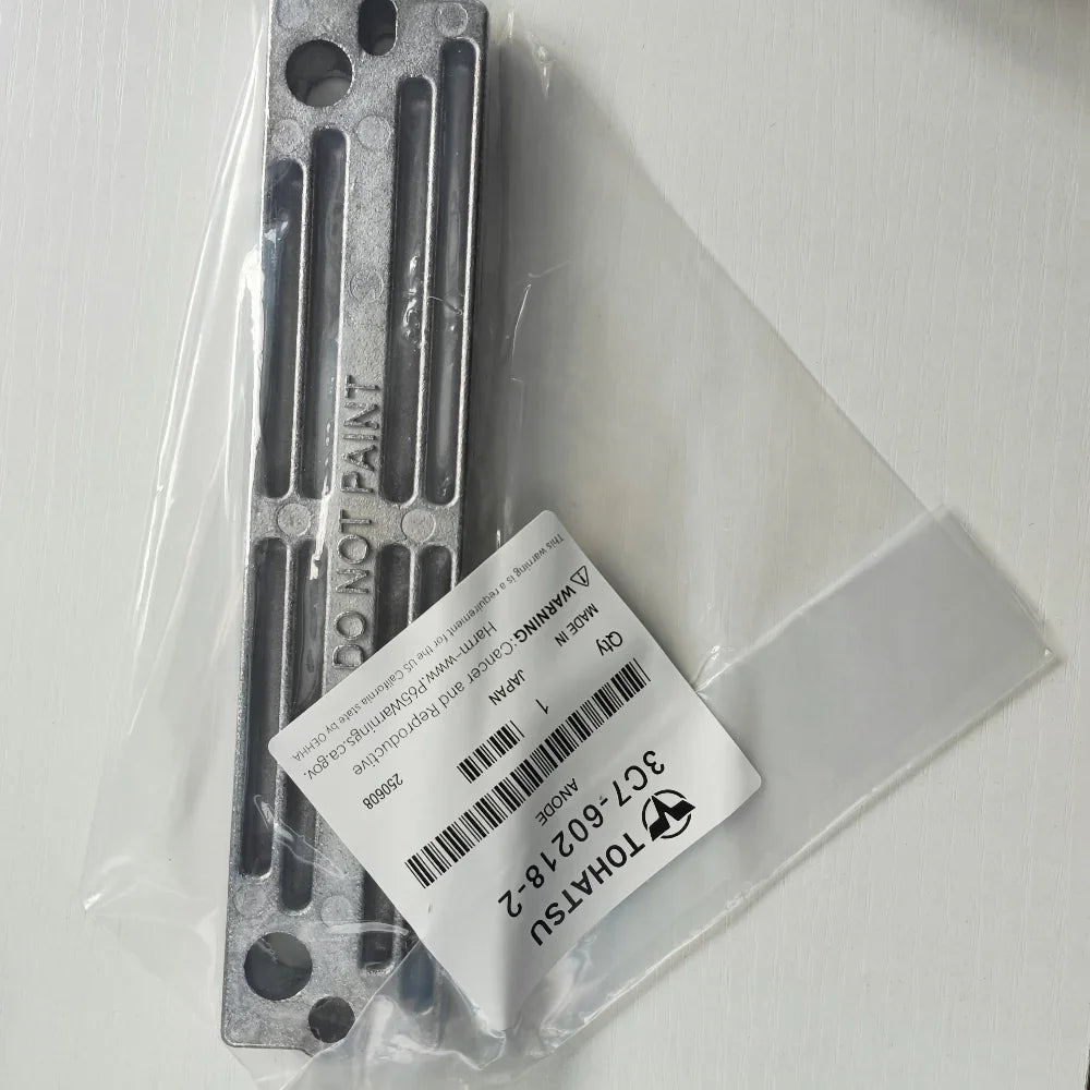 Metal component with label in clear plastic packaging on a white background