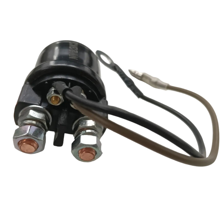 A black electrical relay or solenoid valve with two large silver bolted terminals showing copper contacts, plus two wires (one black, one brown/tan) with a small silver connector, photographed on a light gray surface.